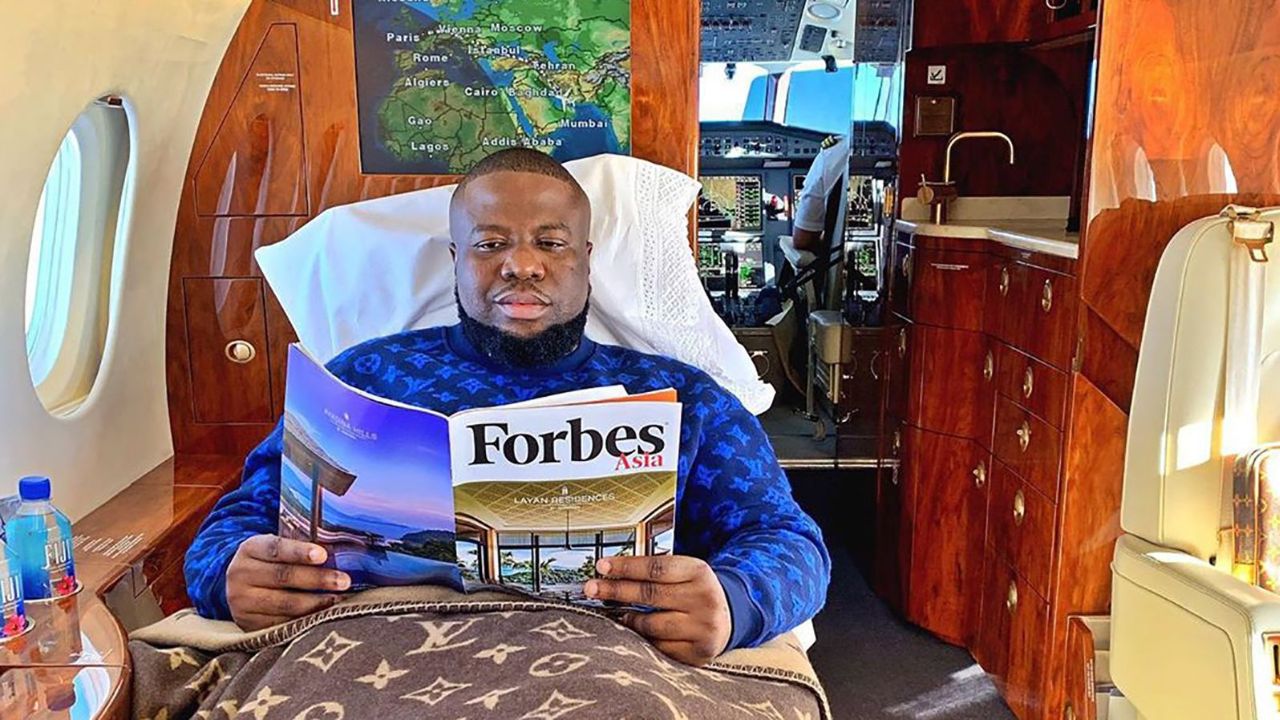 Ramon "Hushpuppi" Abbas reading Forbes in bed on a private jet